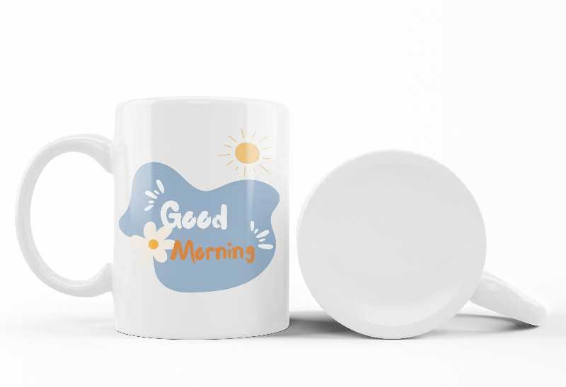 Two ceramic mugs, one with a 'Good Morning' message and a sun design, and the other featuring a floral arrangement of blue and orange flowers.