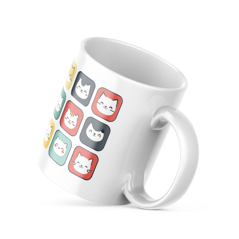 A ceramic coffee mug with a colorful cat face pattern on one side and a 'Good Morning' message with paw prints on the other, placed inside and outside of the mug.