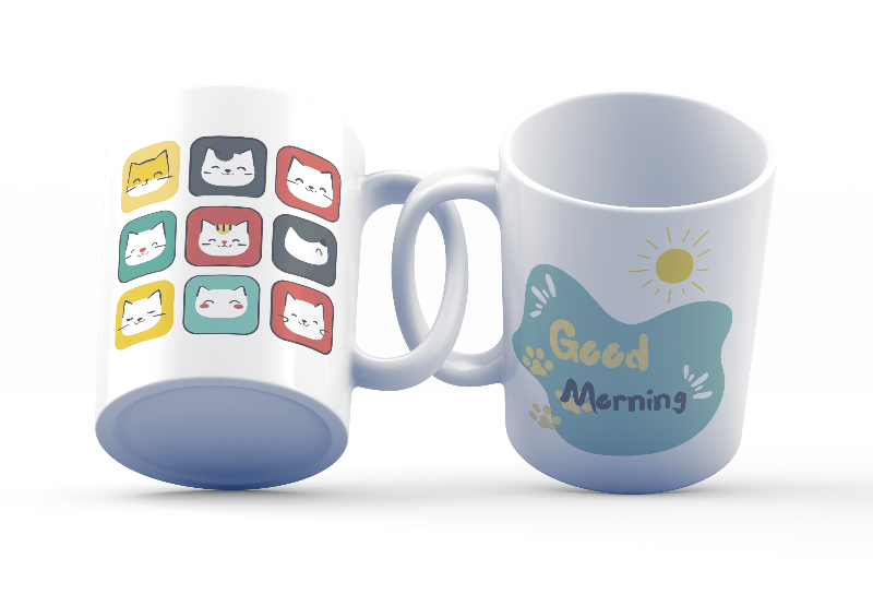 A ceramic coffee mug with a colorful cat face pattern on one side and a 'Good Morning' message with paw prints on the other, placed inside and outside of the mug.