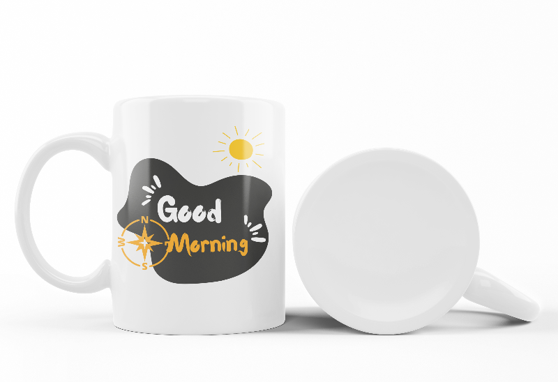 Two ceramic mugs side by side, one with a mountain design and the other with a sunrise and sunburst design, both featuring text 'Good Morning'.
