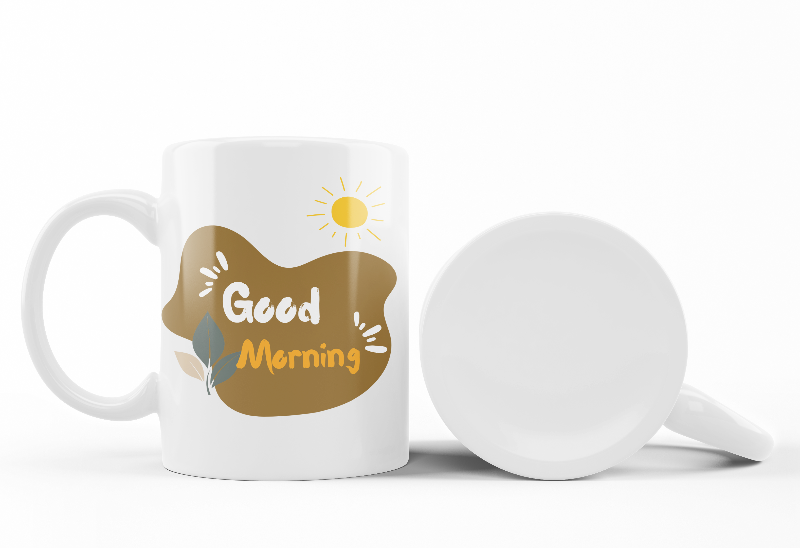 Two ceramic mugs side by side, one with a 'Good Morning' design and the other featuring a scenic nature landscape with trees and a sun rise.