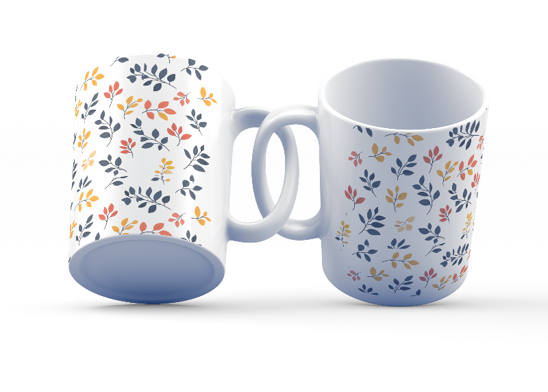 A set of two ceramic coffee mugs with a floral and autumn leaf design on a white background, one mug is filled with a liquid, possibly coffee or tea.