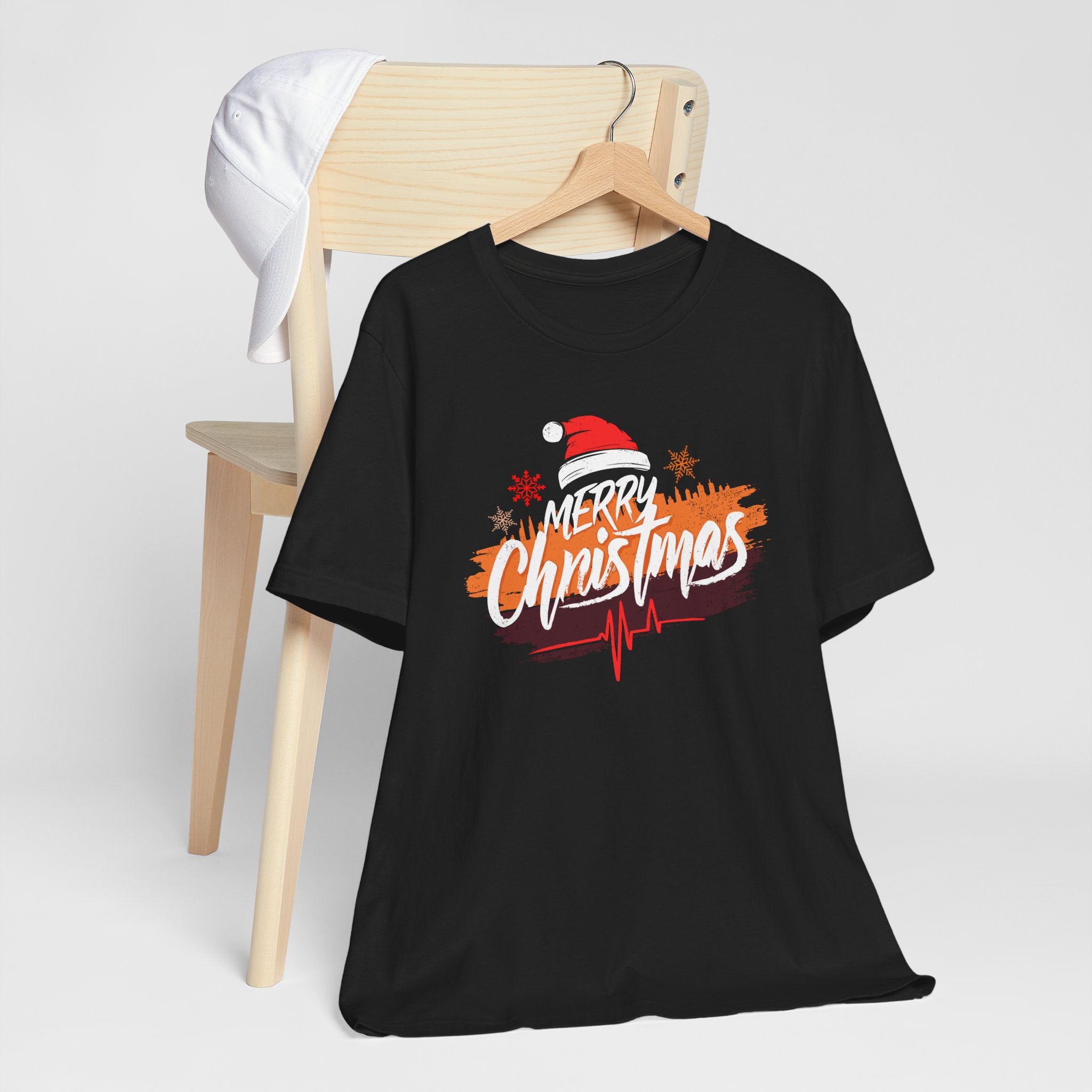Black t-shirt with 'Merry Christmas' design on a wooden chair against a white background