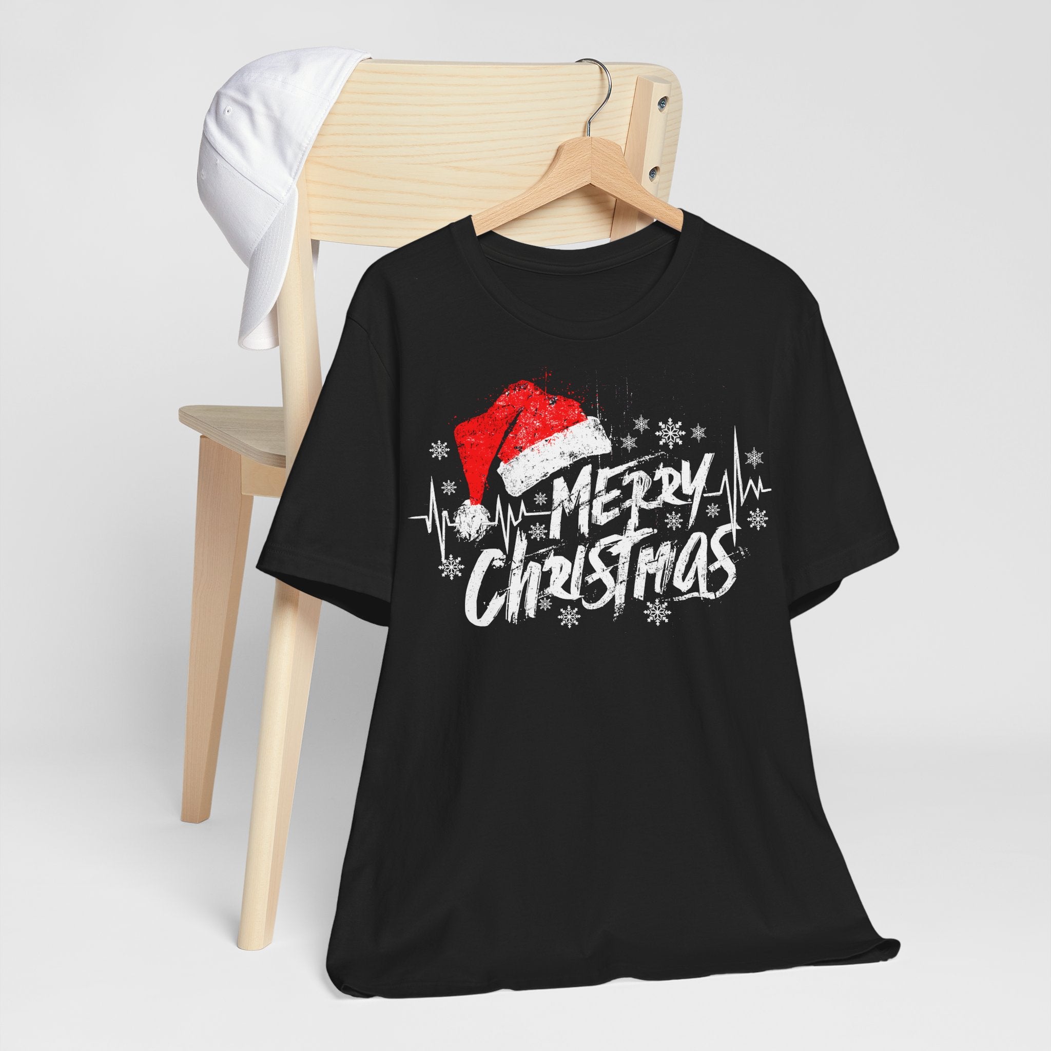 Black t-shirt with Christmas design on a wooden chair against a white background
