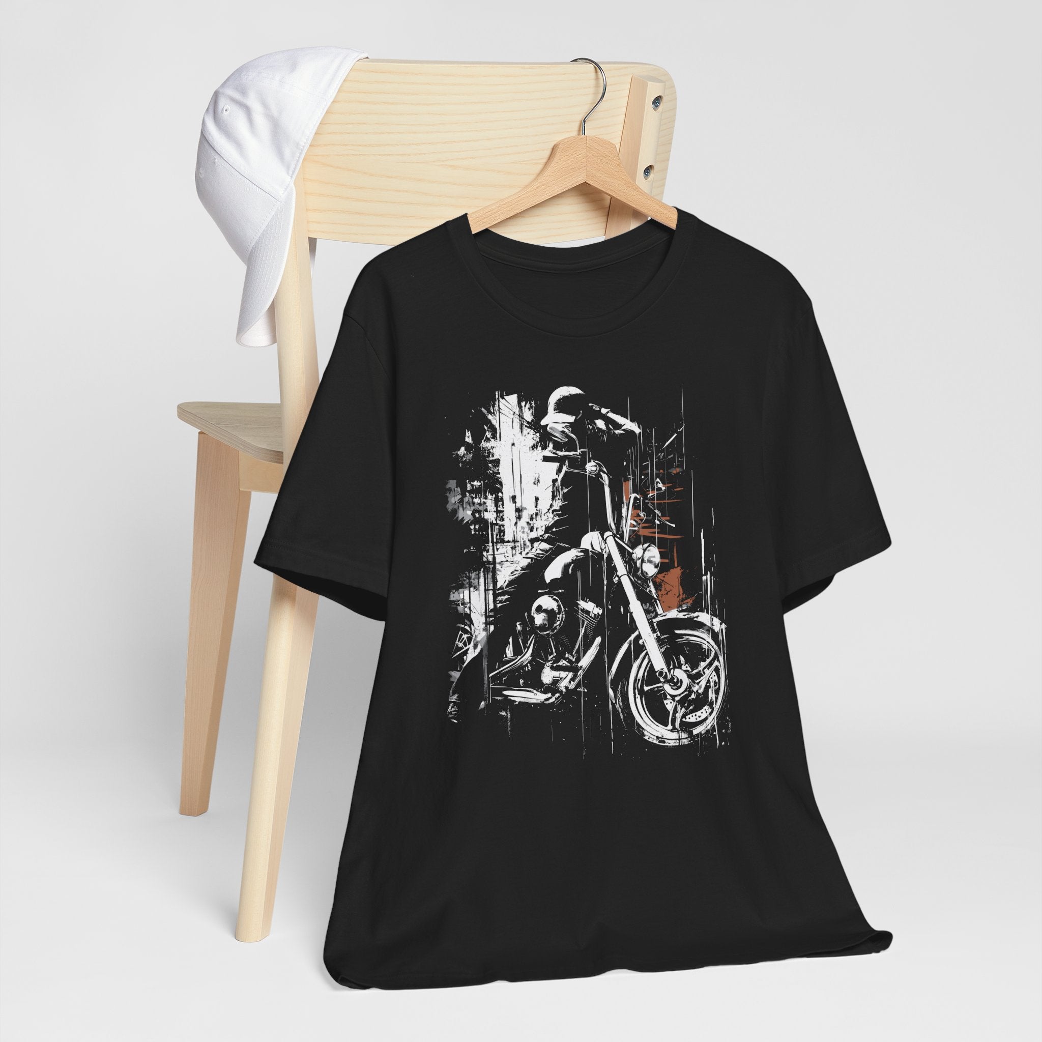 Black t-shirt with motorcycle graphic on a wooden chair against a white background