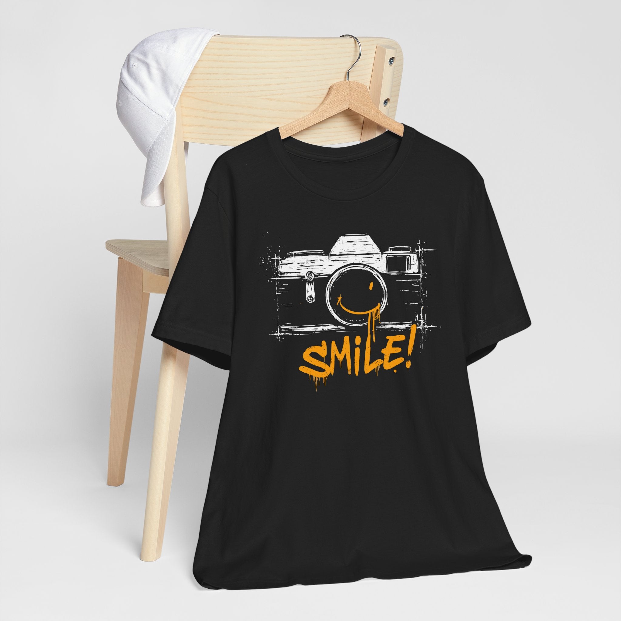 Black t-shirt with camera graphic and 'SMILE!' text on a white background