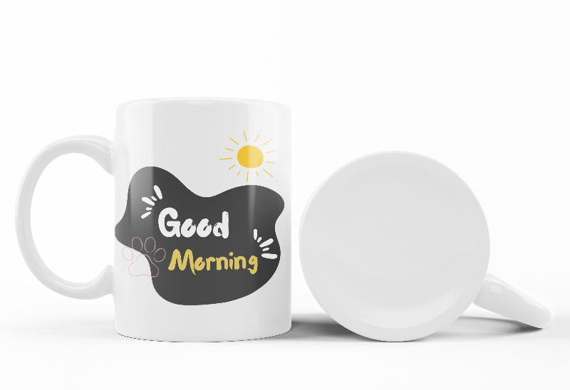 Two ceramic mugs, one with a 'Good Morning' text and paw prints, and the other featuring a black cat holding a yellow umbrella.