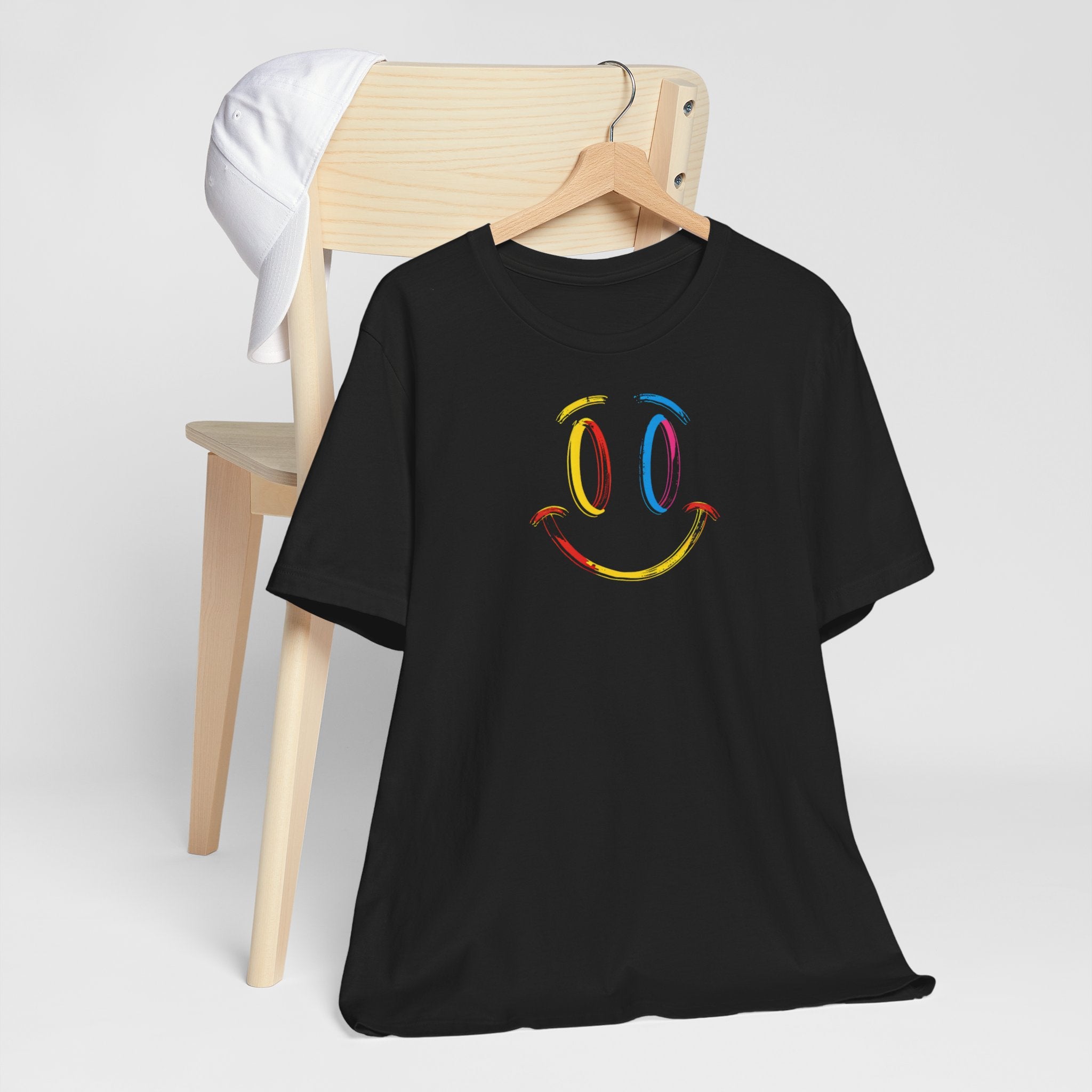 A black t-shirt with a vibrant colorful smiley face design on the front.