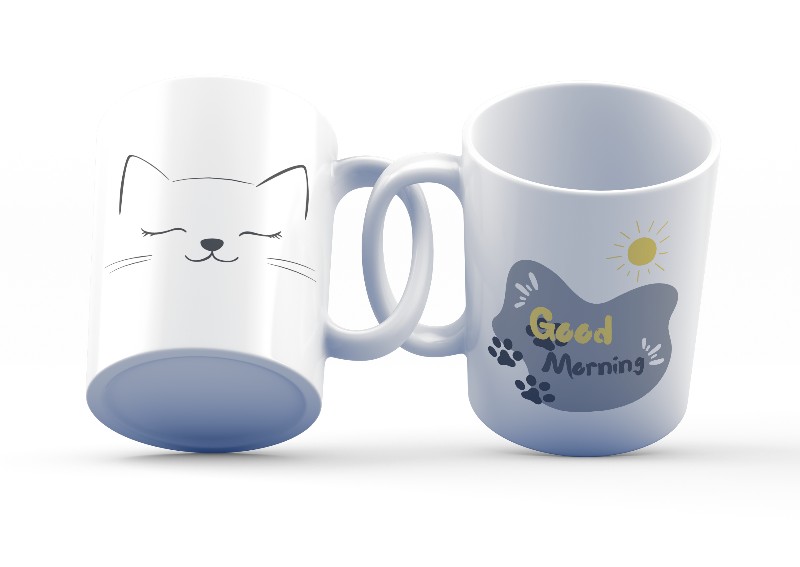 Two ceramic coffee mugs, one with a cat face illustration and 'Good Morning' text, the other with a sun design and 'Good Morning' text. Both have white interiors.