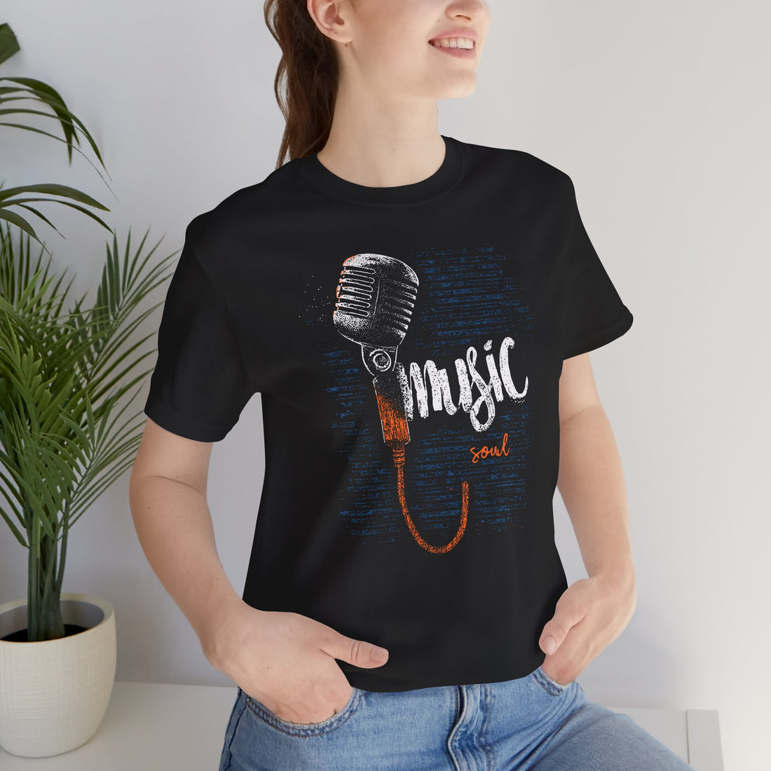 Person wearing a black t-shirt with a microphone graphic and 'music soul' text, standing indoors.