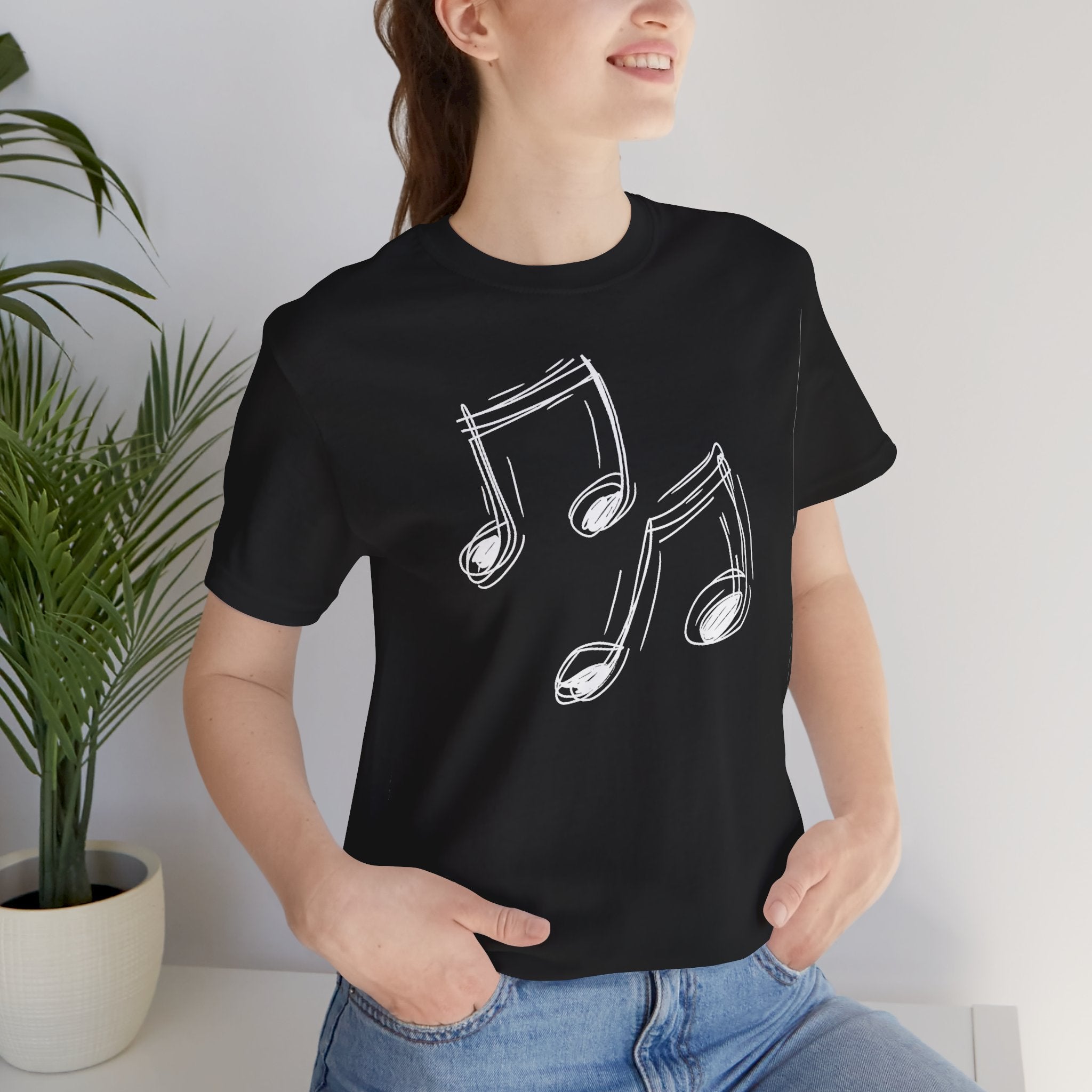 A black cotton t-shirt with a minimalist white hand-drawn music notes design on the front.