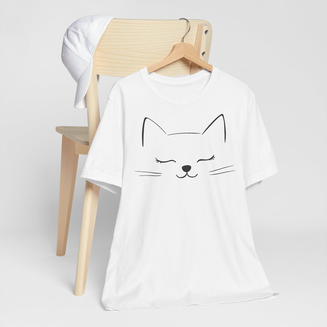 White cotton T-shirt with a minimalist design of a closed-eyed cat face on the front.
