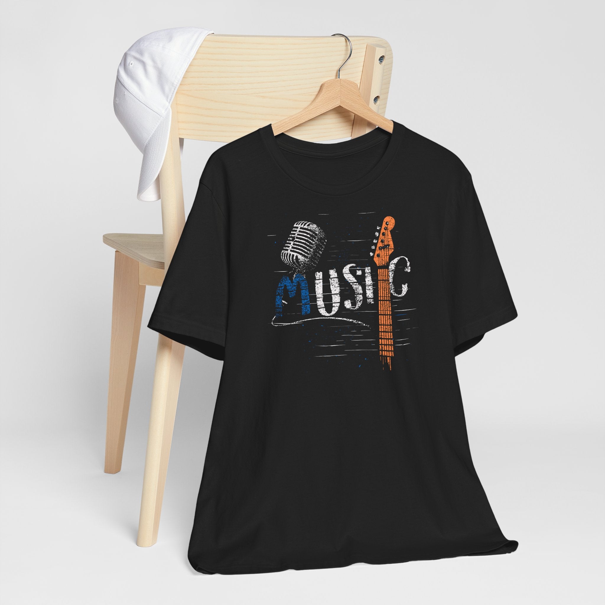 Black t-shirt with 'Music' graphic design on a wooden chair against a white background