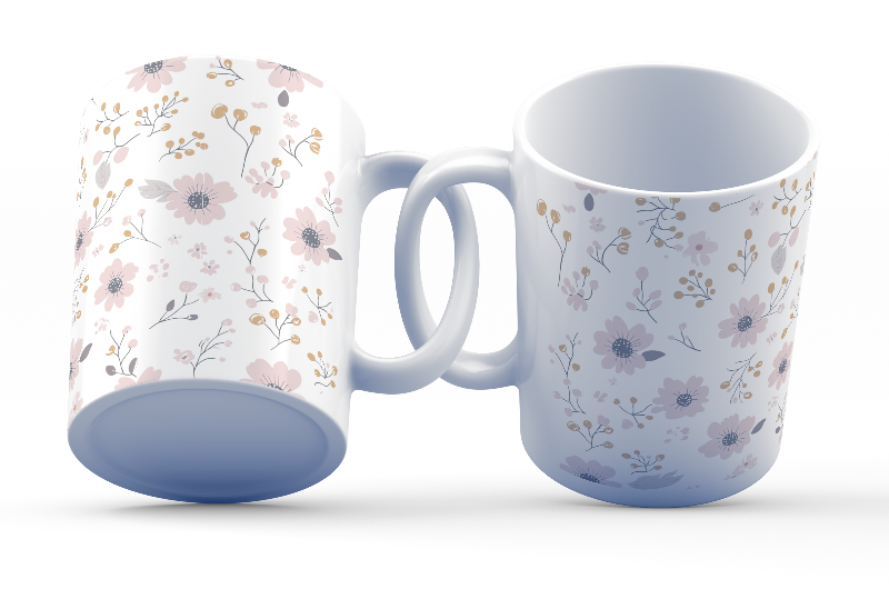 Two ceramic coffee mugs with a floral pattern, one with the handle up and the other with the handle down, on a white background.