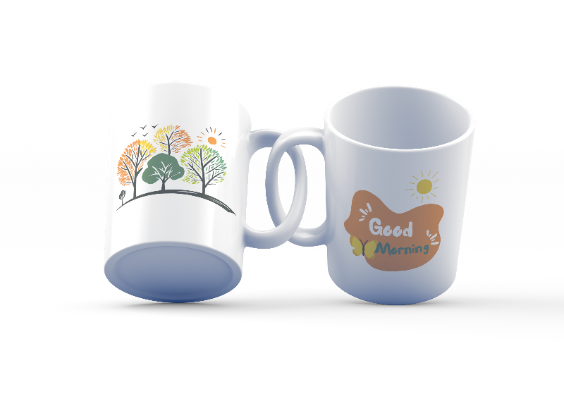 Two ceramic mugs with nature-inspired designs. One mug displays a colorful forest scene with trees and the sun, while the other mug has a 'Good Morning' message with a sun and coffee-related graphics.