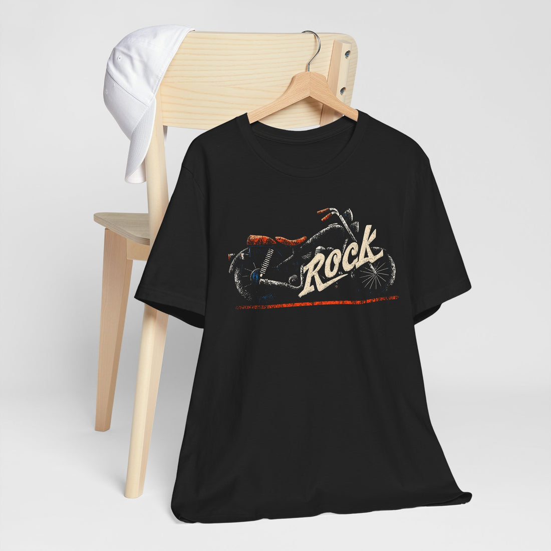 Black t-shirt with graphic design and 'Rock' text on a wooden chair against a white background