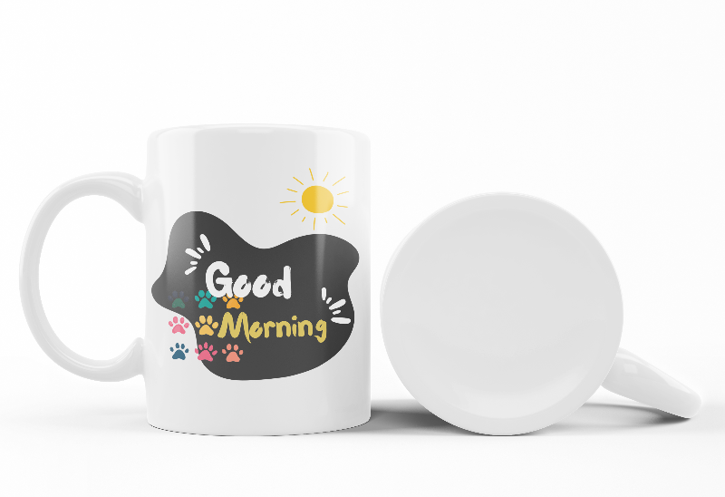 Two ceramic mugs, one with a 'Good Morning' design featuring paw prints and a sun, and the other with a black and white sleeping kitten design.