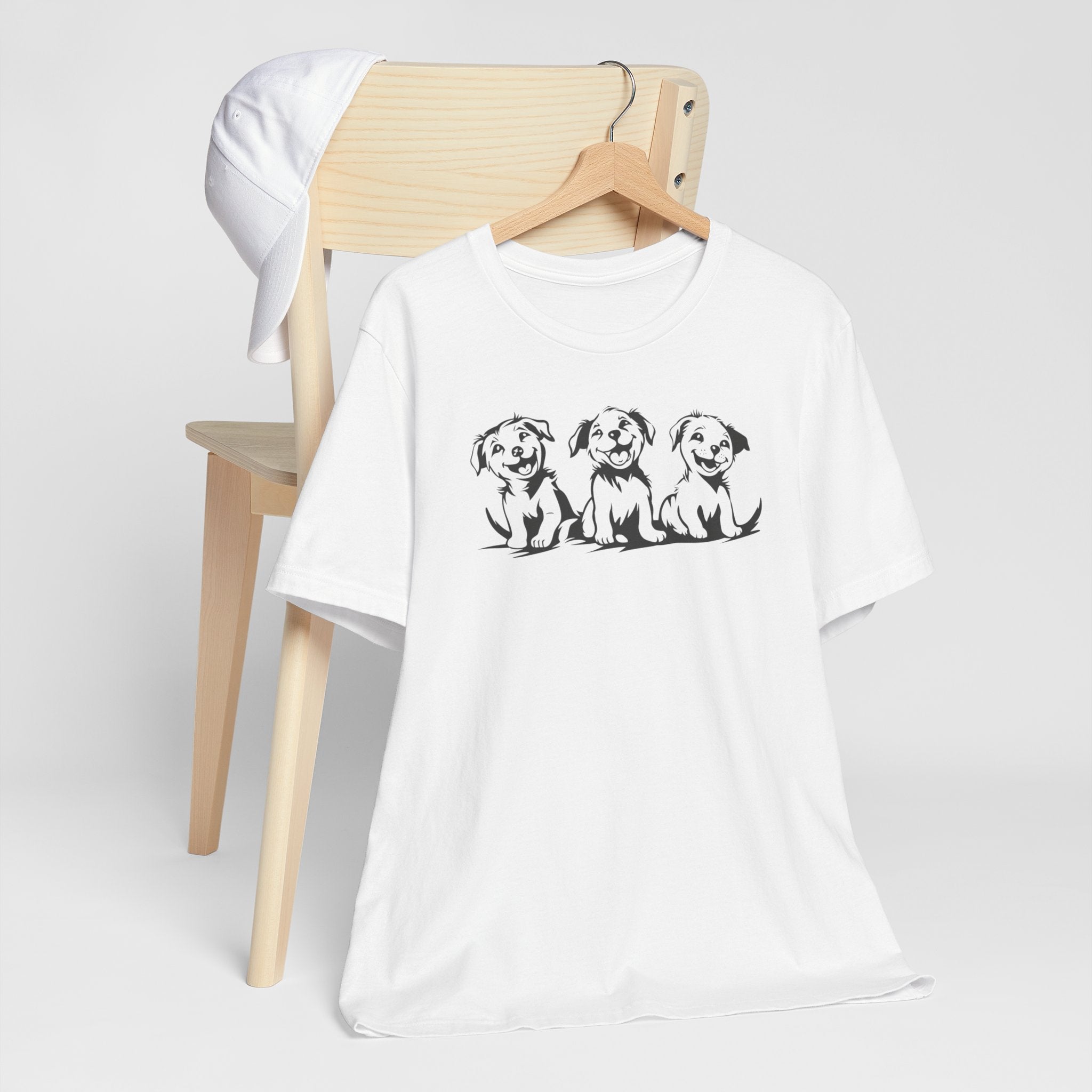A white t-shirt featuring a graphic design of three smiling puppies sitting side by side.