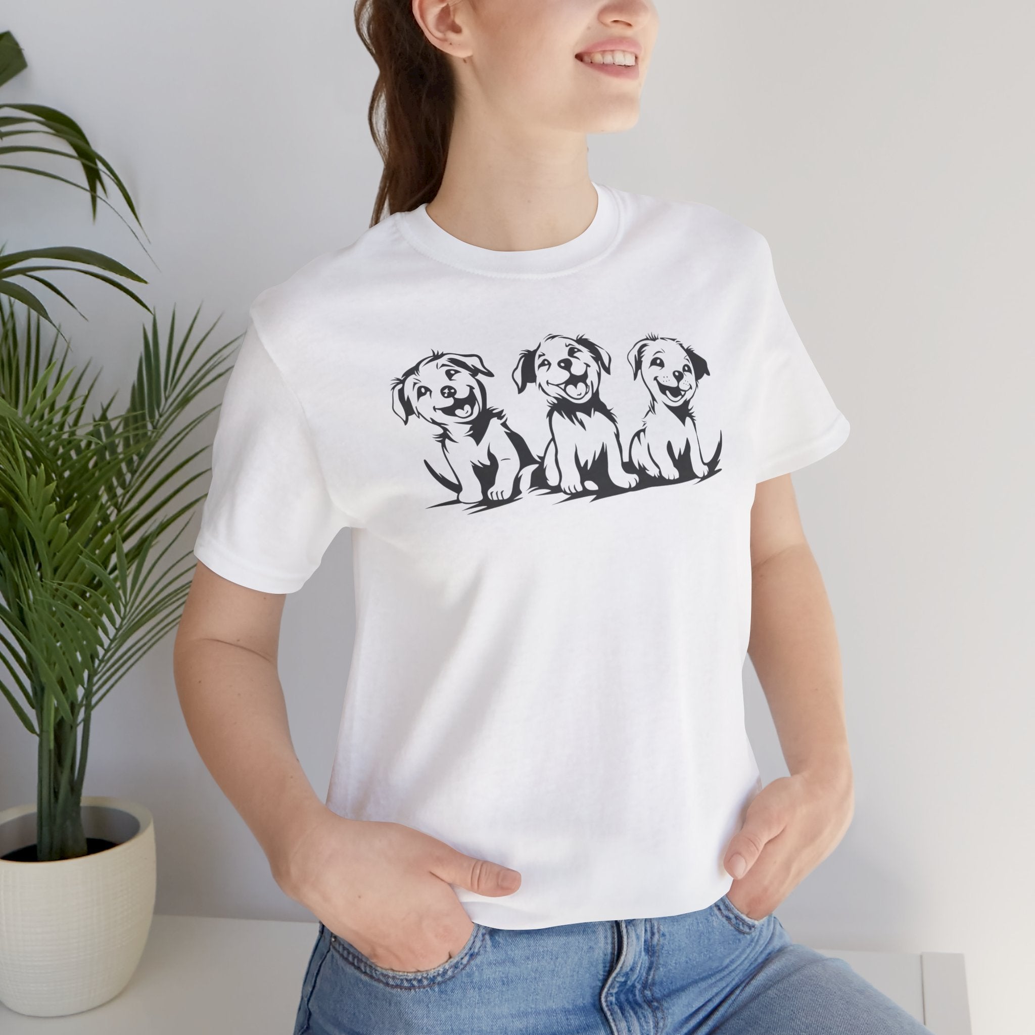 A white t-shirt featuring a graphic design of three smiling puppies sitting side by side.