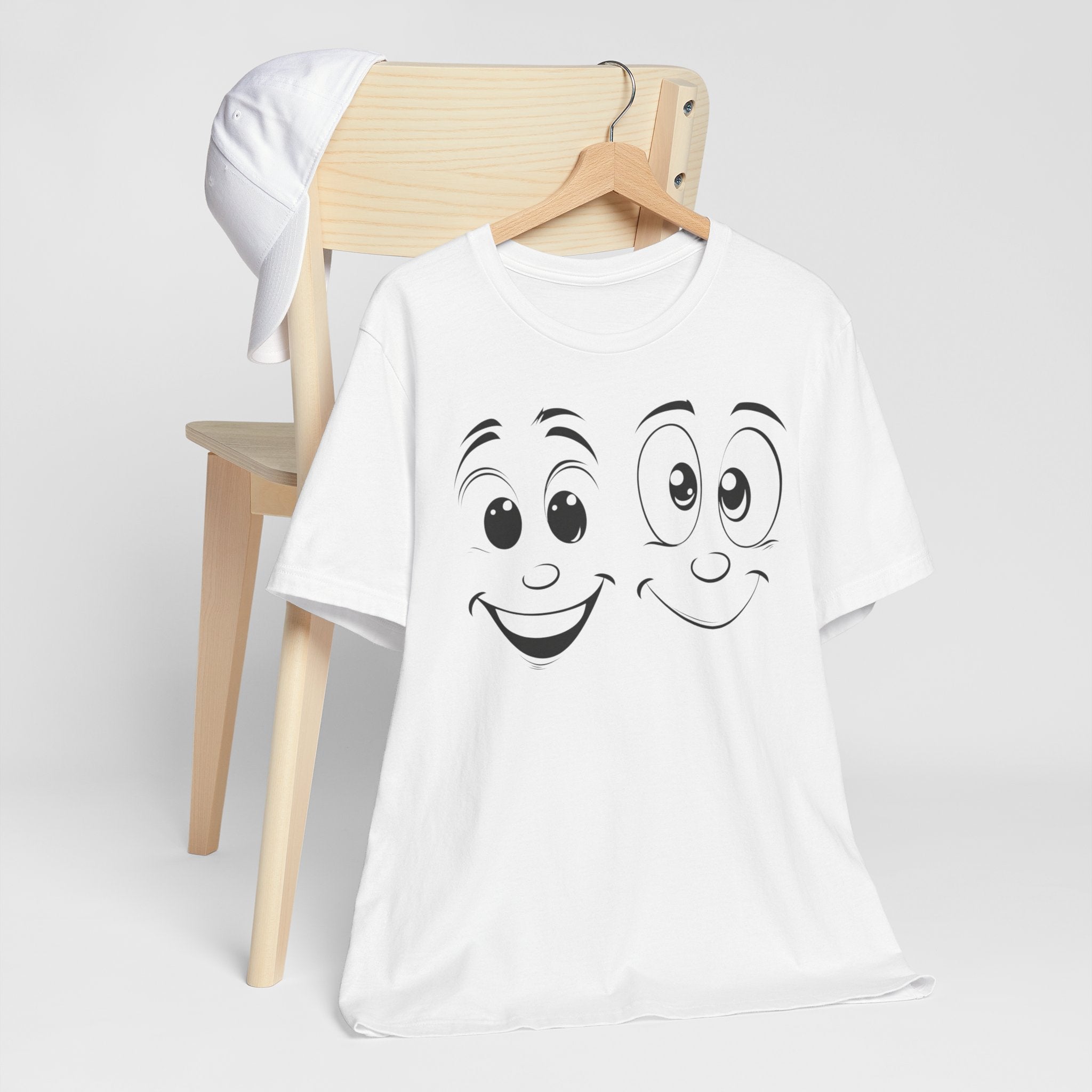 A white cotton tee with a graphic print of two cartoon faces with smiles on it.