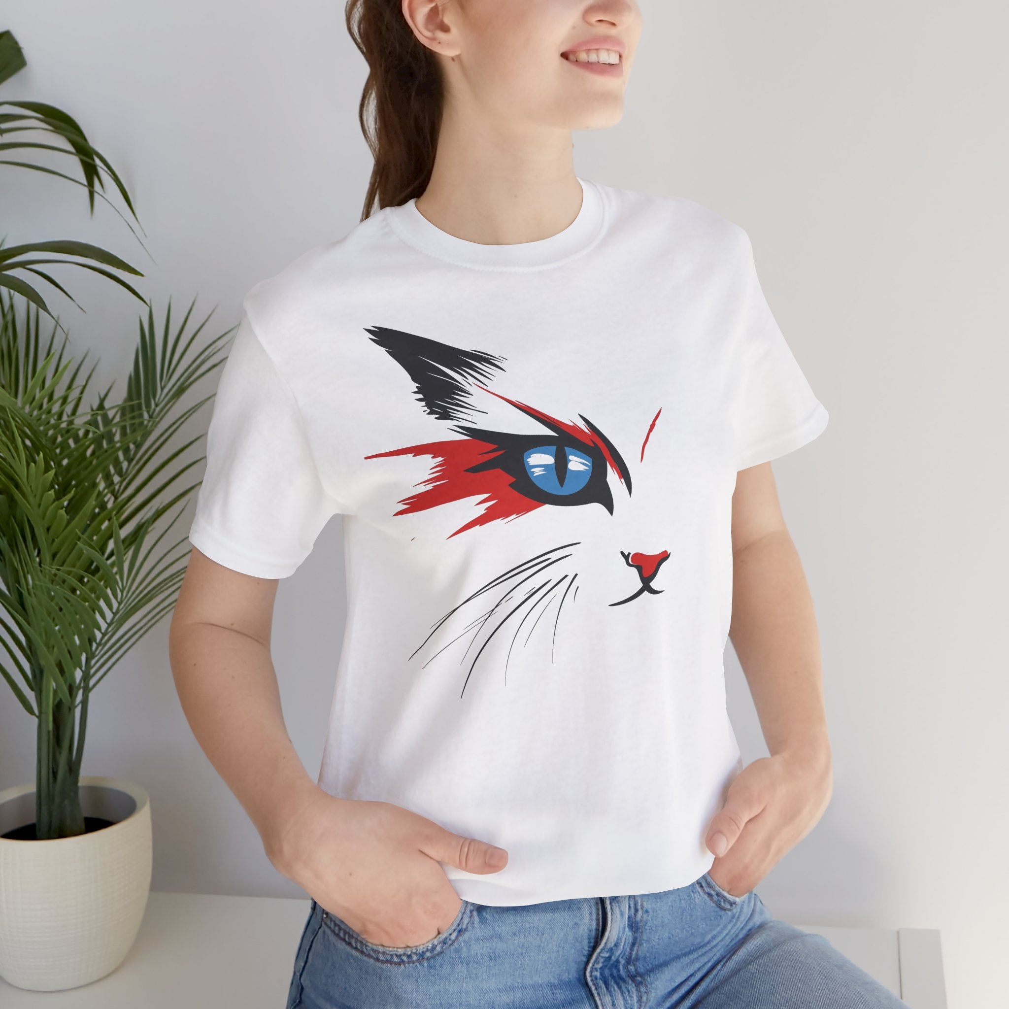 White cotton tee with a bold and artistic design of a cat's face featuring vibrant red, black, and blue colors.