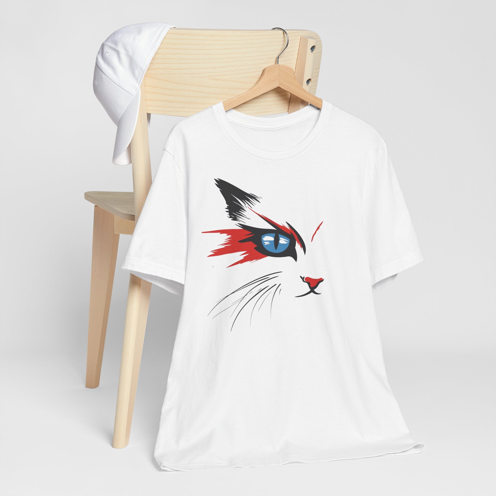 White cotton tee with a bold and artistic design of a cat's face featuring vibrant red, black, and blue colors.