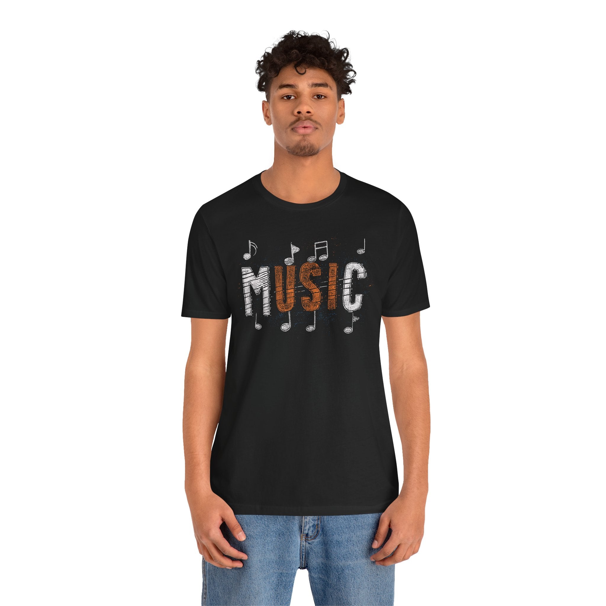 Person wearing a black t-shirt with 'MUSIC' and musical notes design on a white background