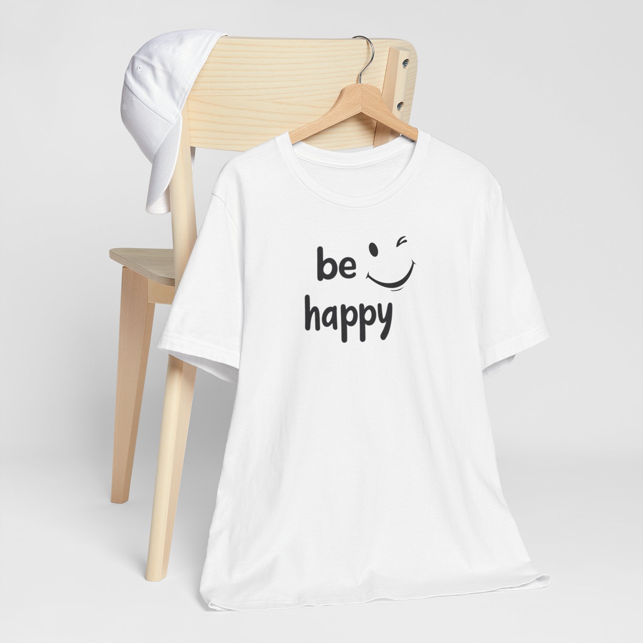A black crew neck t-shirt with the text 'BE HAPPY' and a smiley face design on the front.