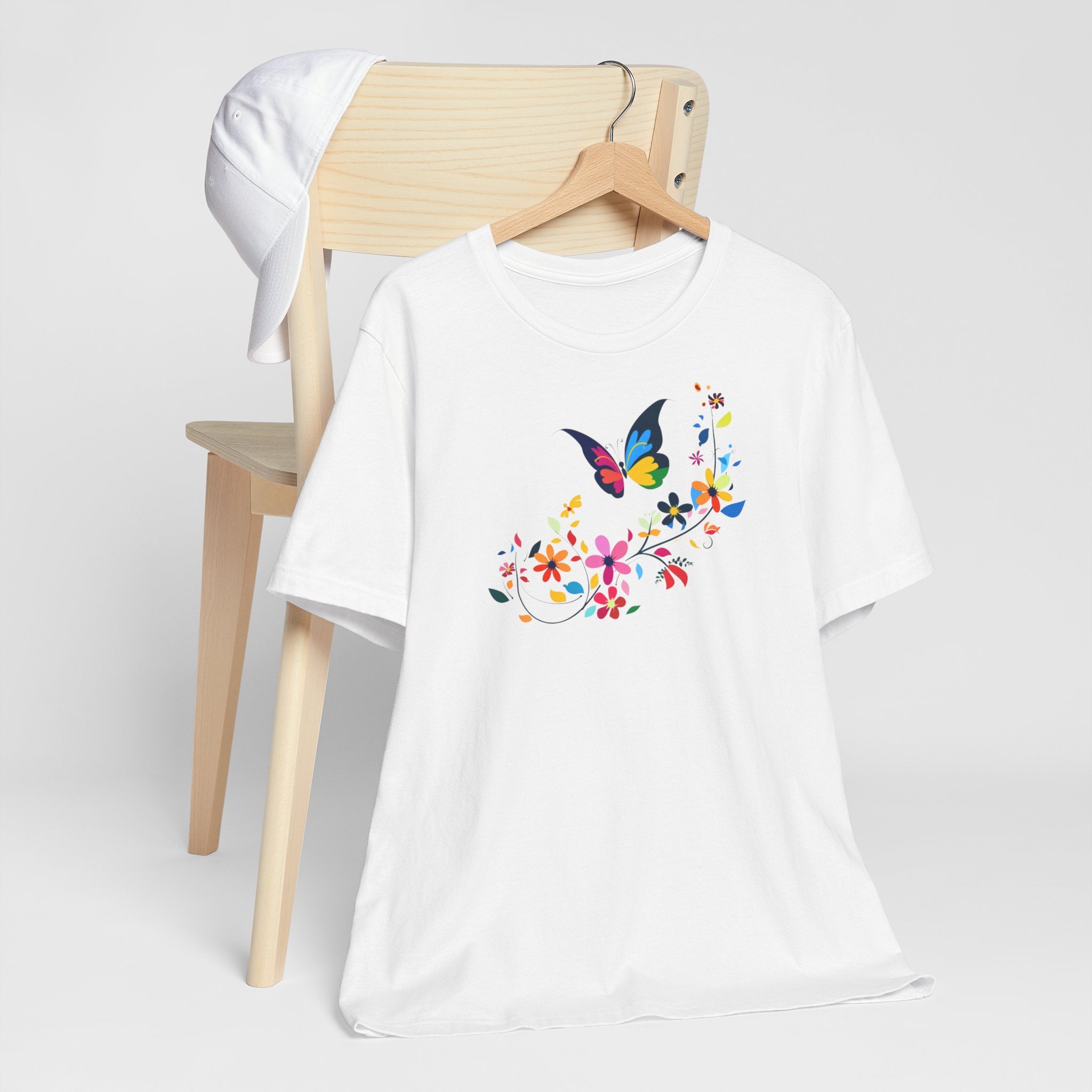 A white crew neck t-shirt with a colorful butterfly and floral pattern on the front.