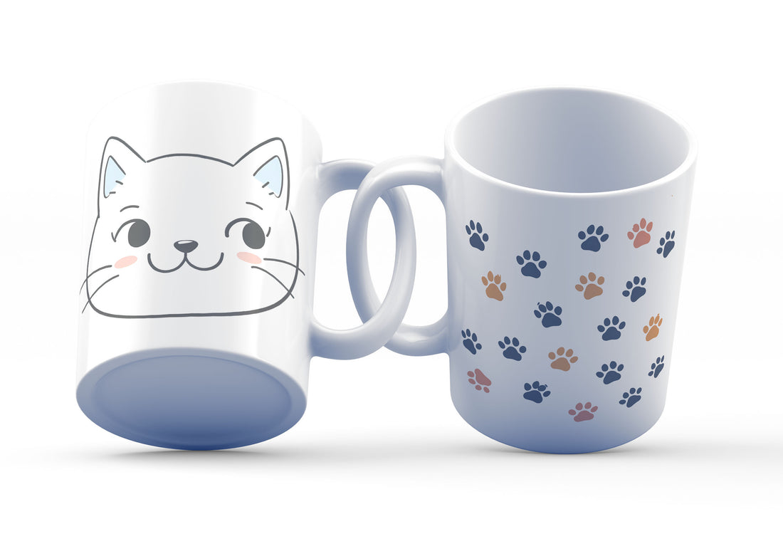 A ceramic mug with a cute cat face design on the front and blue paw prints on the back.