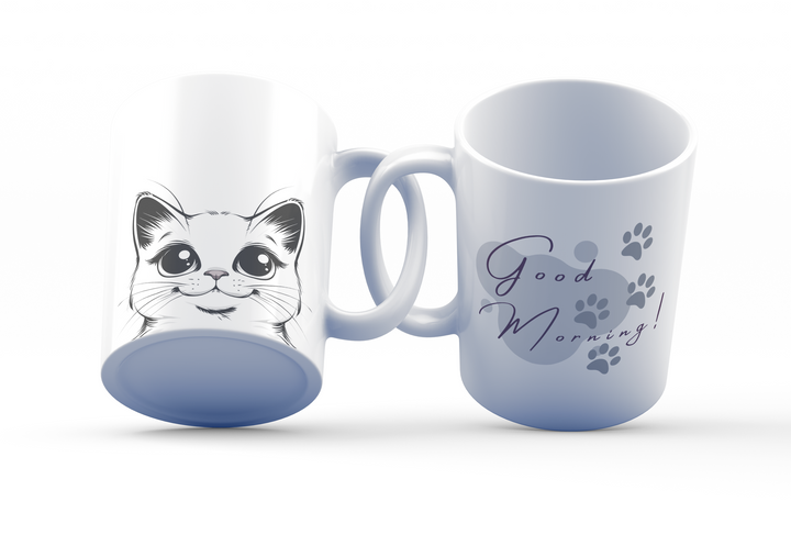 Two white ceramic mugs with cat-themed designs. One features a cat face with a 'Good Morning' paw print design.