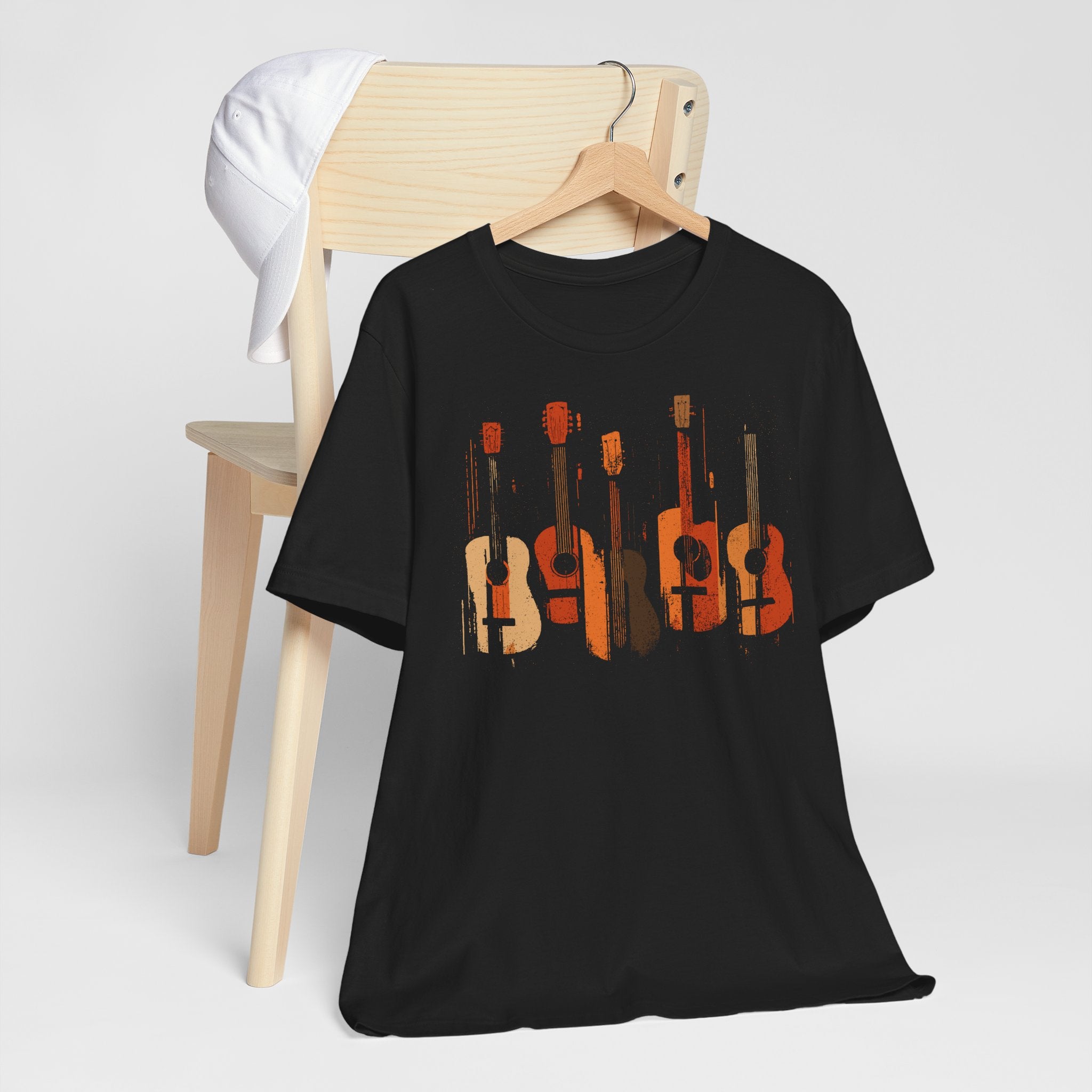 Black t-shirt with guitar design on a hanger against a white background