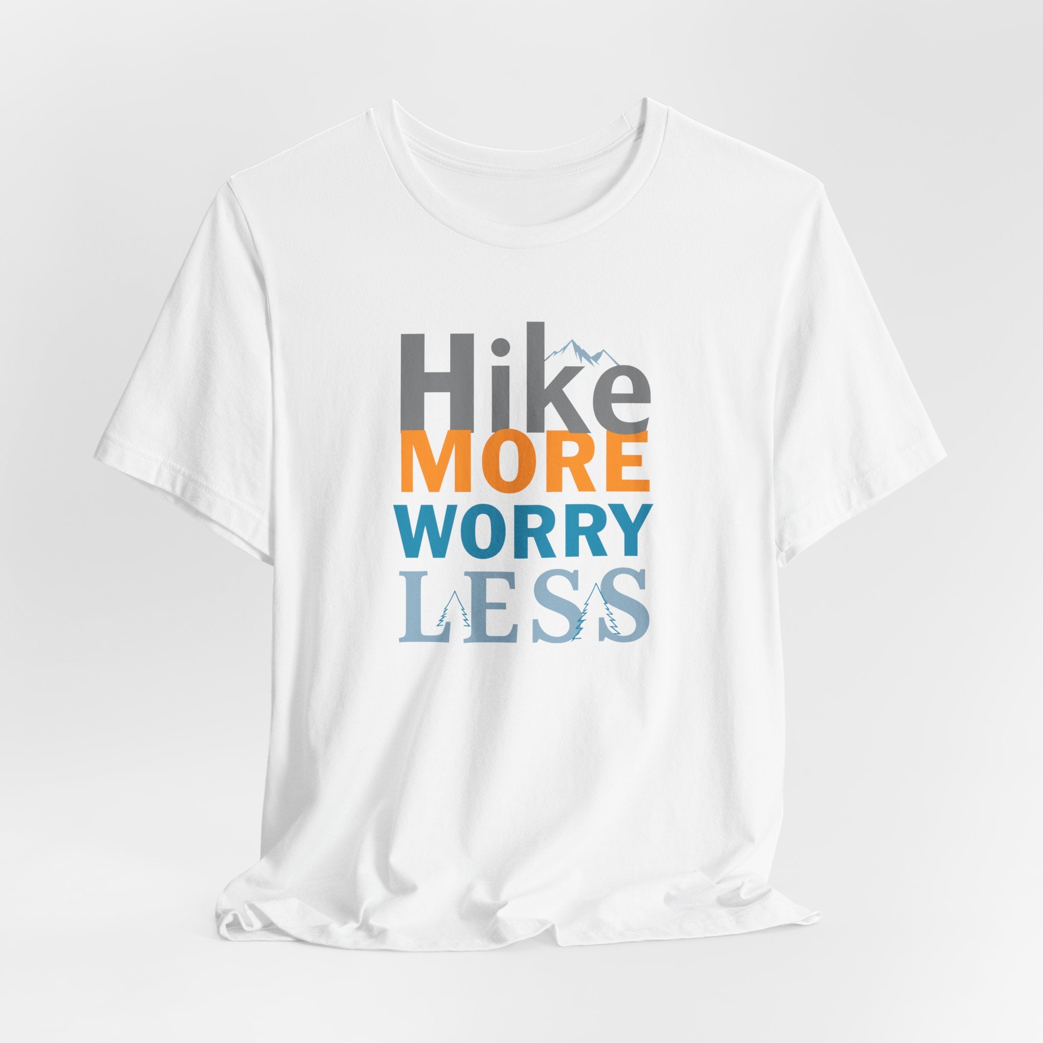 White crew neck t-shirt with the text 'Hike More Worry Less' printed in a gradient of orange, gray, and blue.