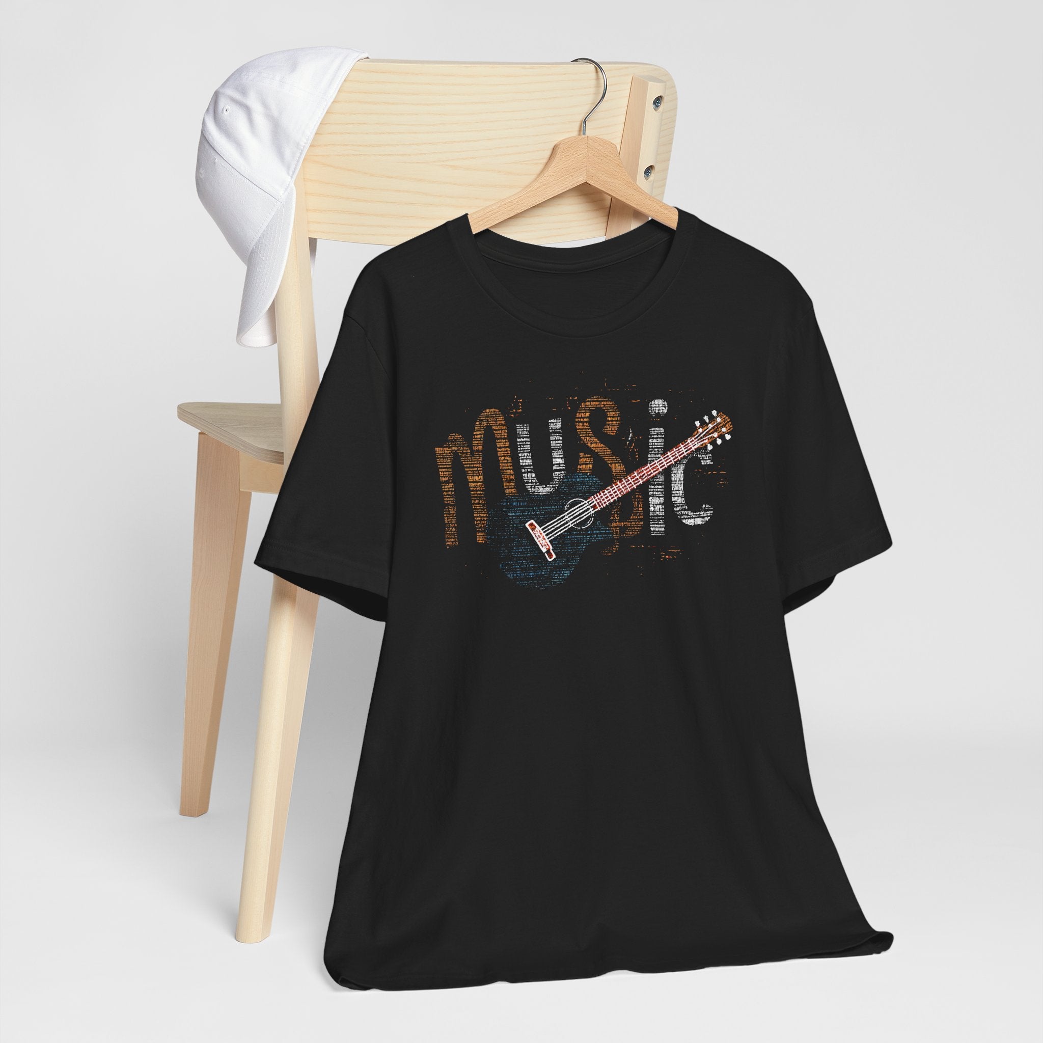 Black t-shirt with 'Music' and guitar design on a hanger against a white background