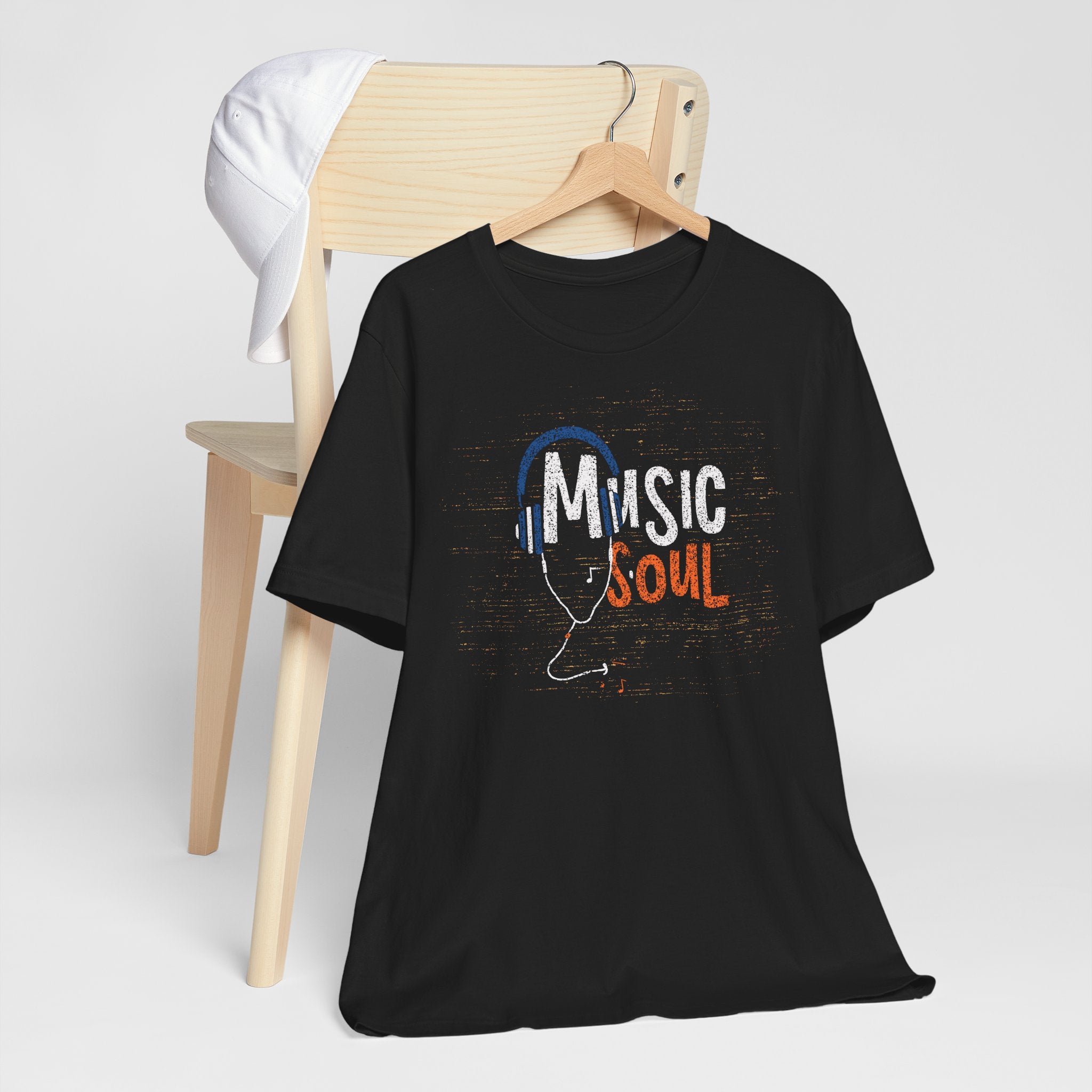 Black t-shirt with 'Music Soul' design on a wooden chair against a white background