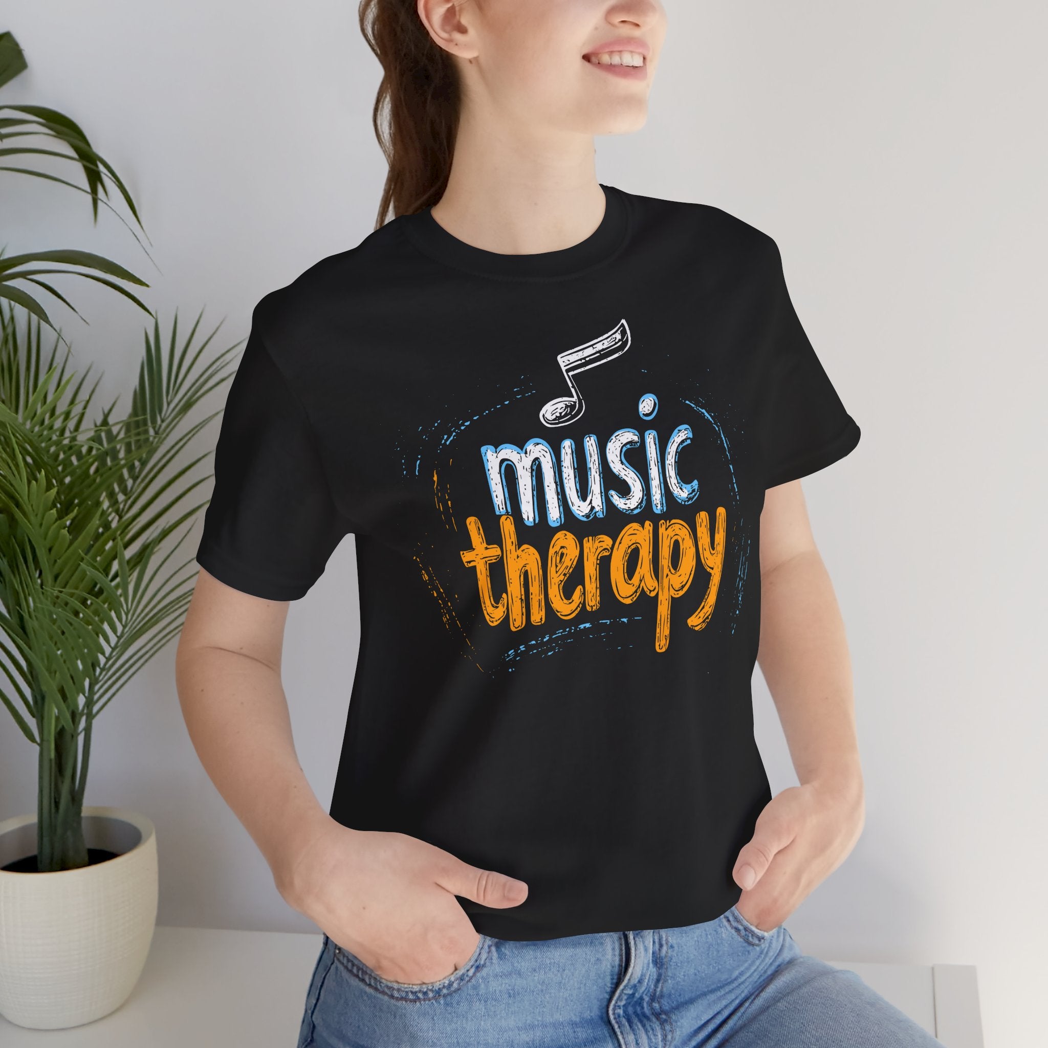 Person wearing a black t-shirt with 'music therapy' text and musical note design.