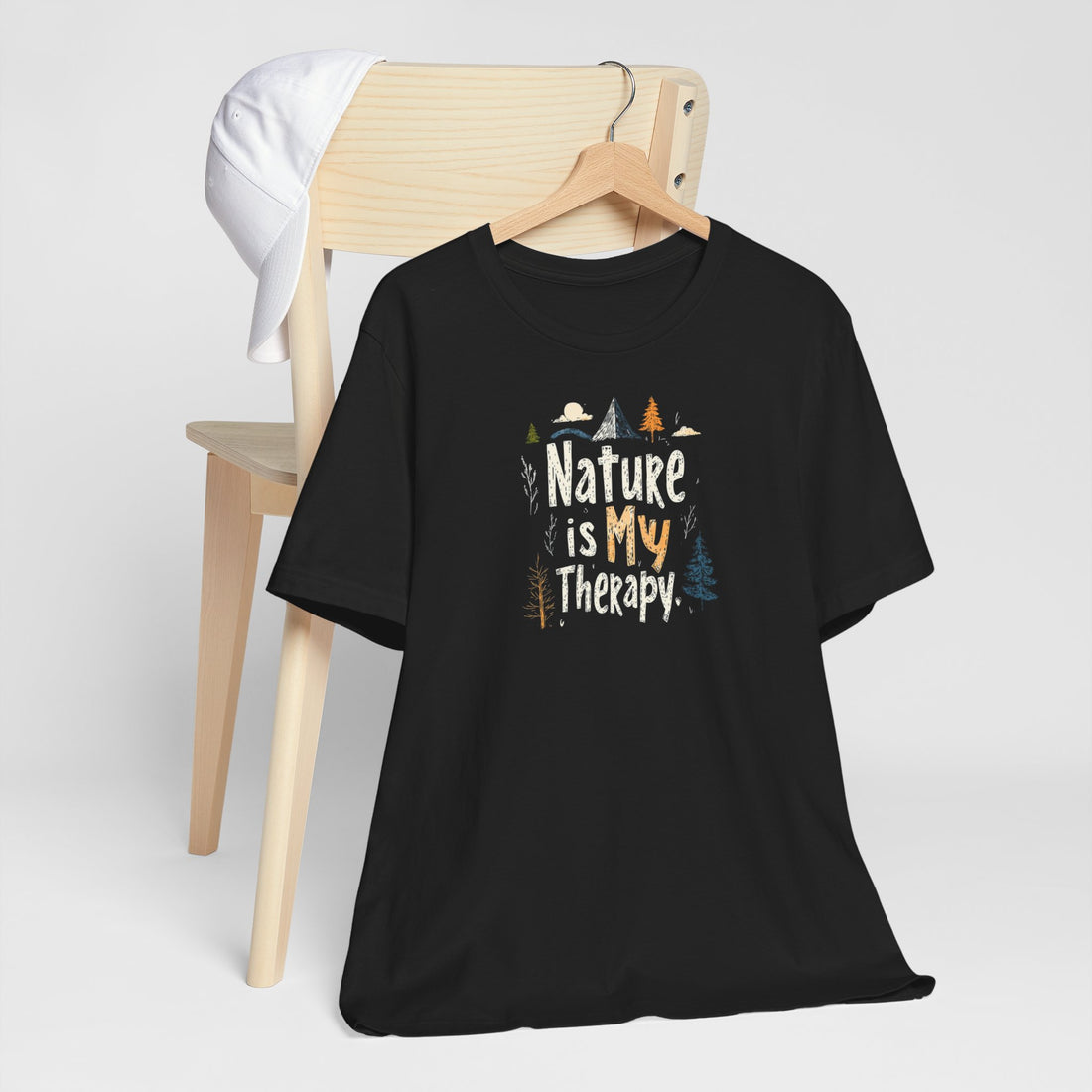 A black cotton t-shirt with a graphic design that includes mountains, trees, and the text 'Nature Is My Therapy'.