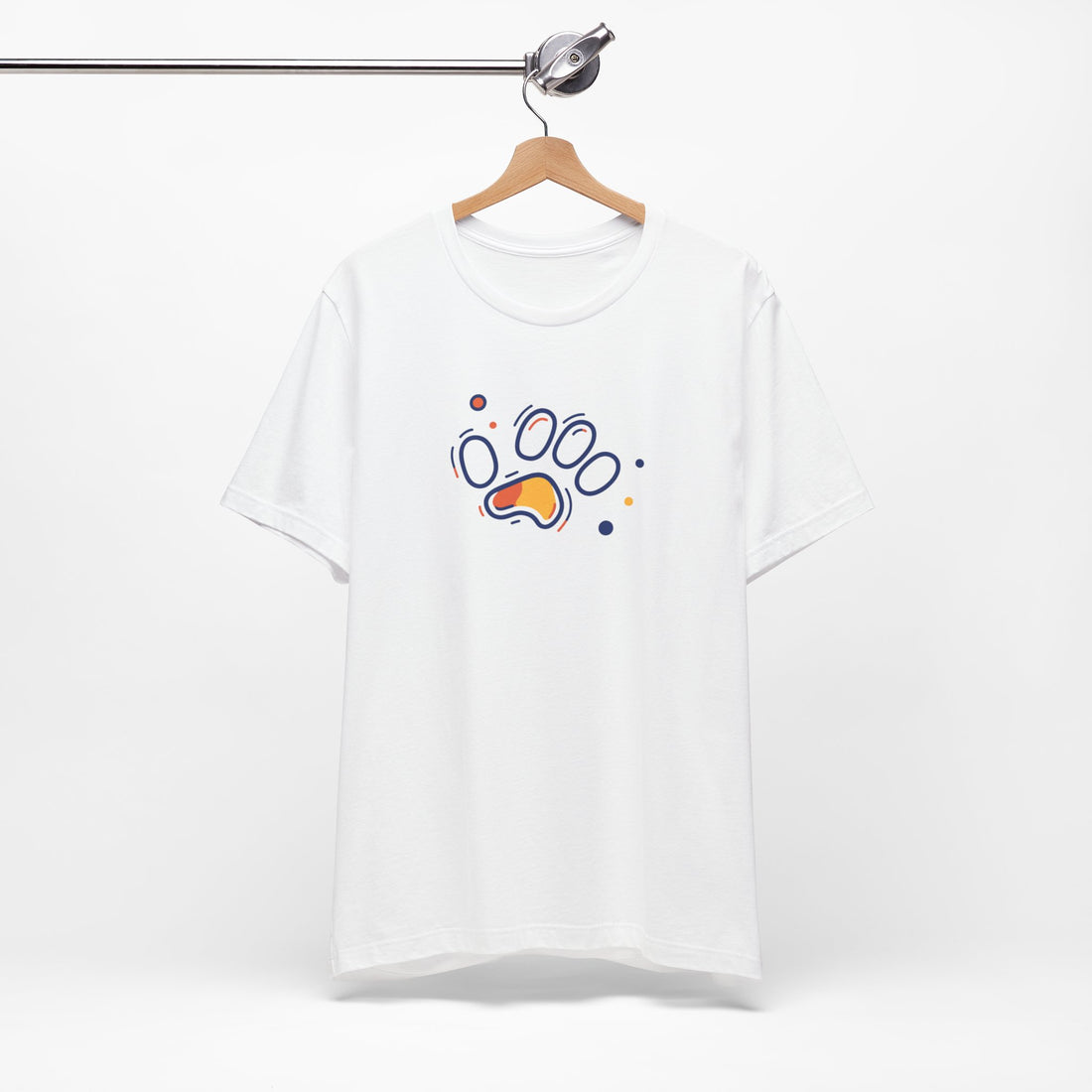 A white cotton t-shirt featuring a vibrant geometric paw print design in orange and navy tones, with abstract shapes.
