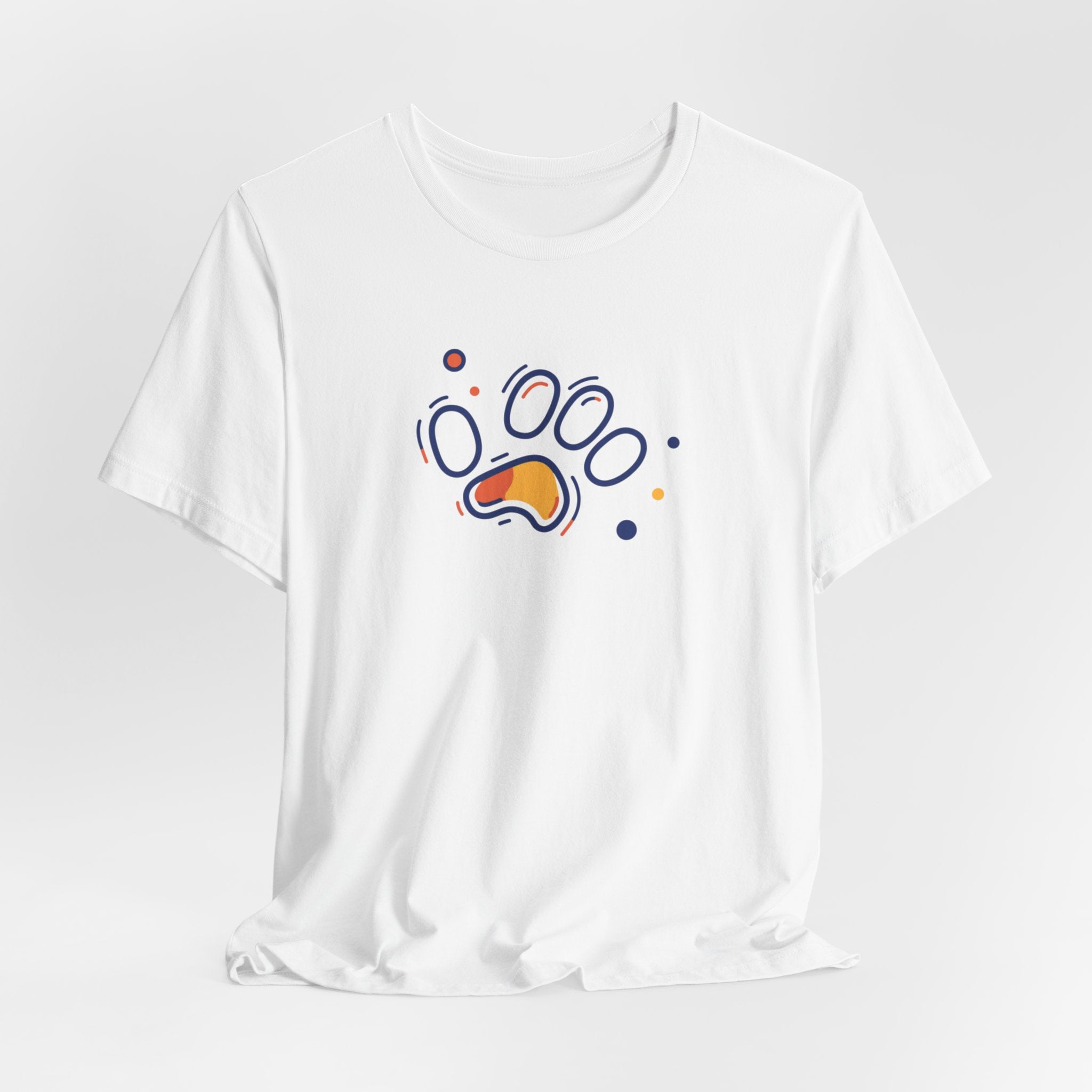A white cotton t-shirt featuring a vibrant geometric paw print design in orange and navy tones, with abstract shapes.