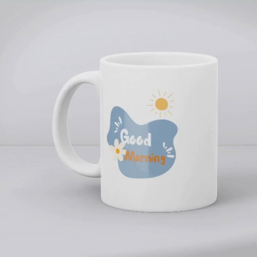 Two ceramic mugs, one with a 'Good Morning' message and a sun design, and the other featuring a floral arrangement of blue and orange flowers.