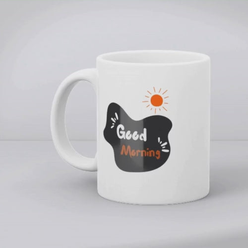 Two ceramic mugs with designs. The first mug has a mountain and tent design with a sun, and the second mug has a 'Good Morning' message with a sun symbol.