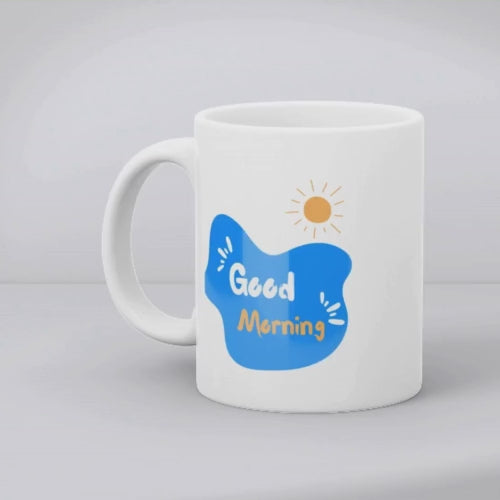 Two ceramic coffee mugs, one with a blue heart design and the other with a 'Good Morning' message alongside a sun icon, both with white backgrounds.
