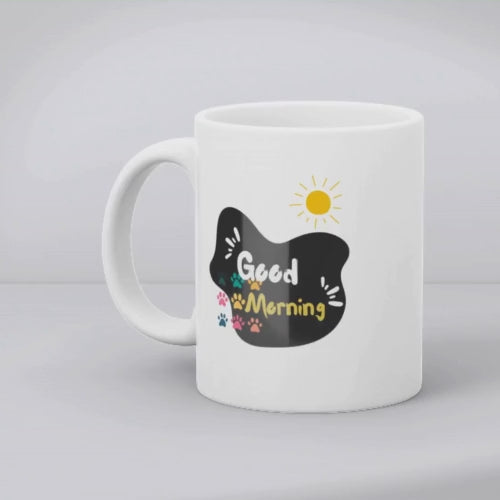 Two ceramic mugs, one with a 'Good Morning' design featuring paw prints and a sun, and the other with a black and white sleeping kitten design.