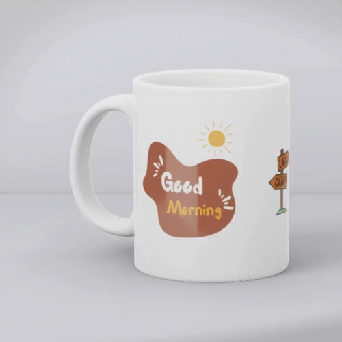 Two ceramic mugs, one with a camping tent and sun design and the other with a 'Good Morning' text and sun design, both in white with colorful illustrations.