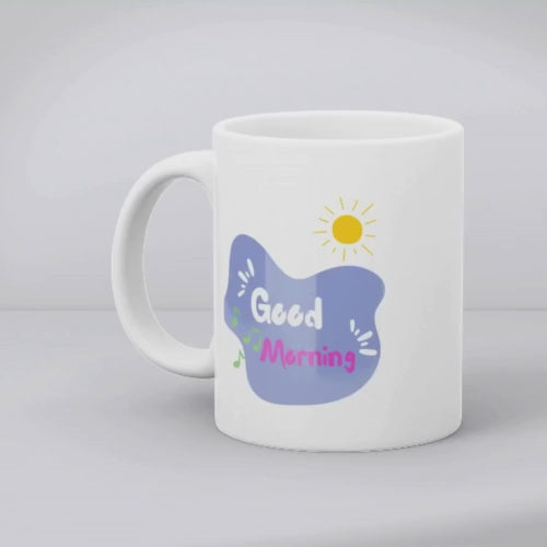 Two ceramic mugs side by side; one with a colorful sketch of headphones and musical notes, and the other with a 'Good Morning' message and a sun icon.