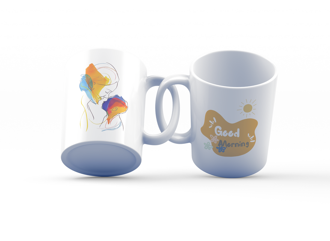 A white ceramic coffee cup with colorful abstract art and a sunrise design, alongside a 'Good Morning' message on the other side, displayed with its shadow.