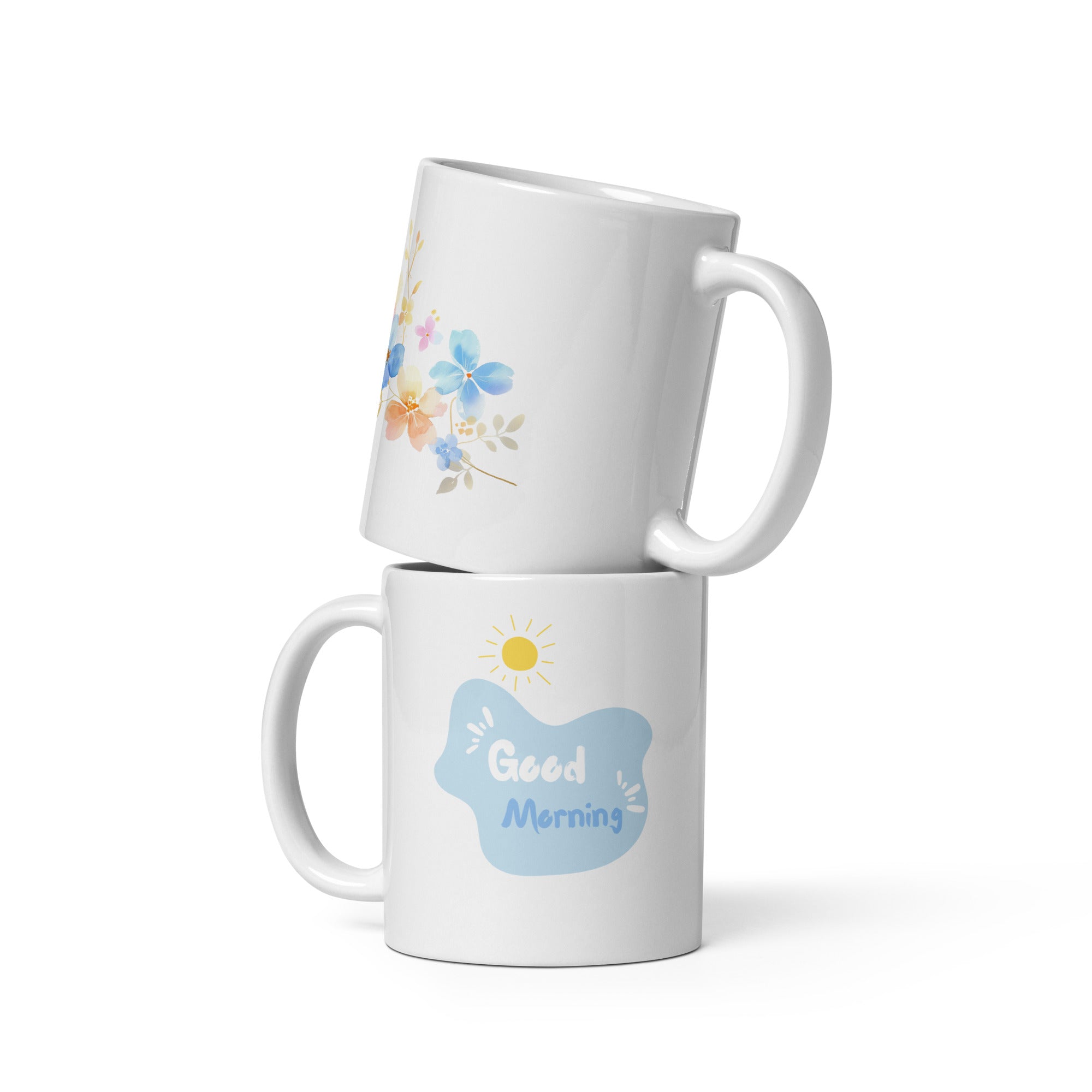 A set of two ceramic mugs, one with a floral watercolor design and the other with a 'Good Morning' message in white text on a blue background, both featuring a handle.