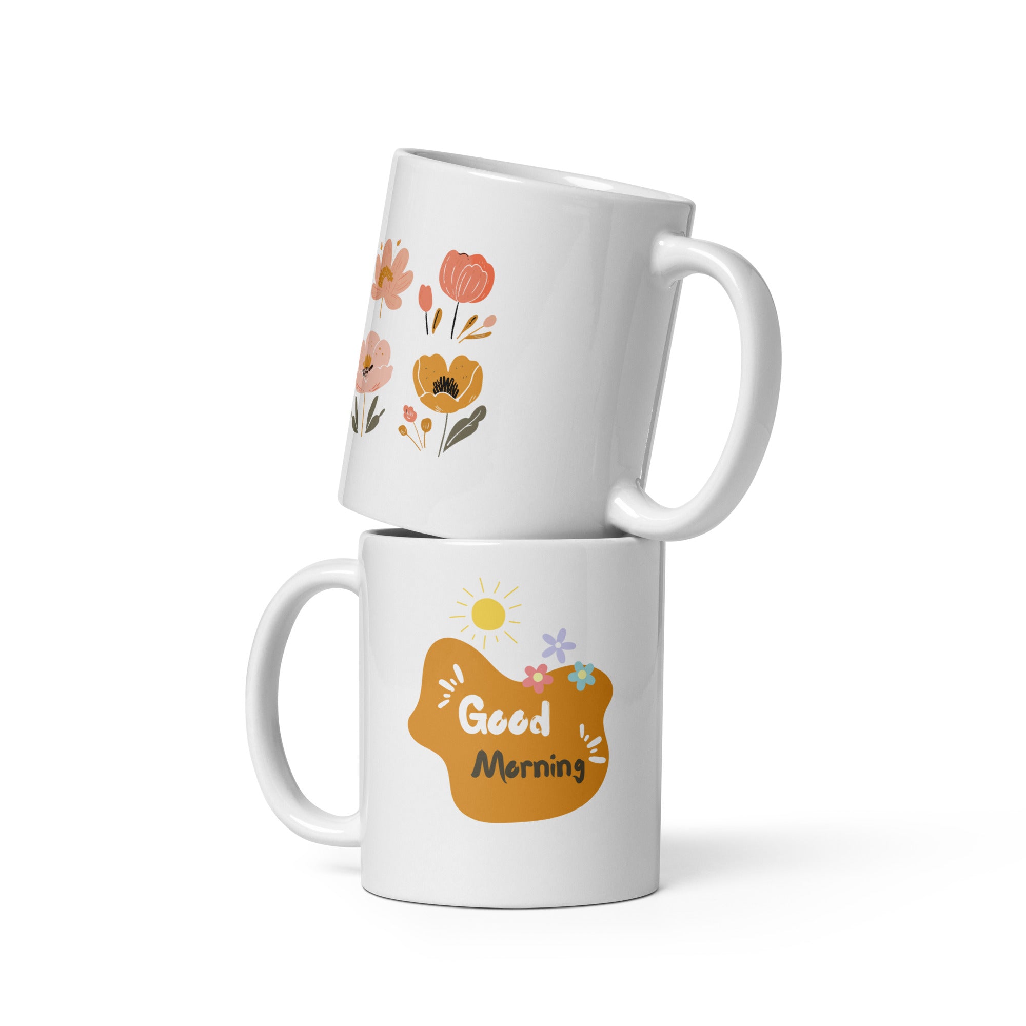 A set of two ceramic mugs, one with a floral design featuring various flowers in earthy tones and the other with a 'Good Morning' message in a golden background. Both mugs have handles and are shown with the inside of one mug facing the viewer.