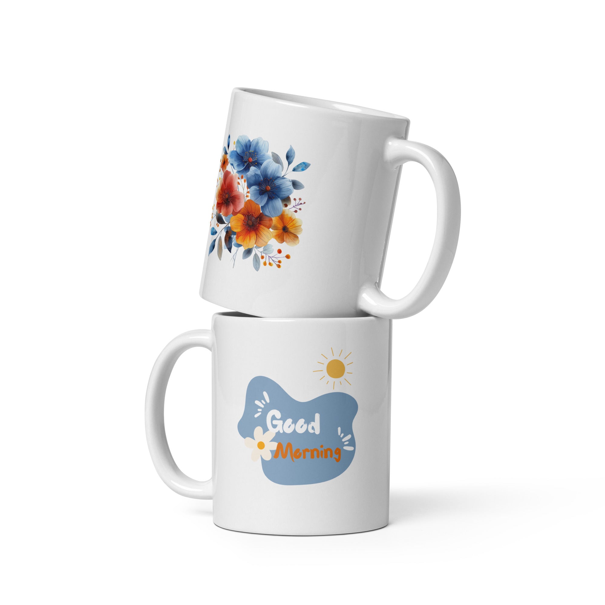Two ceramic mugs, one with a 'Good Morning' message and a sun design, and the other featuring a floral arrangement of blue and orange flowers.