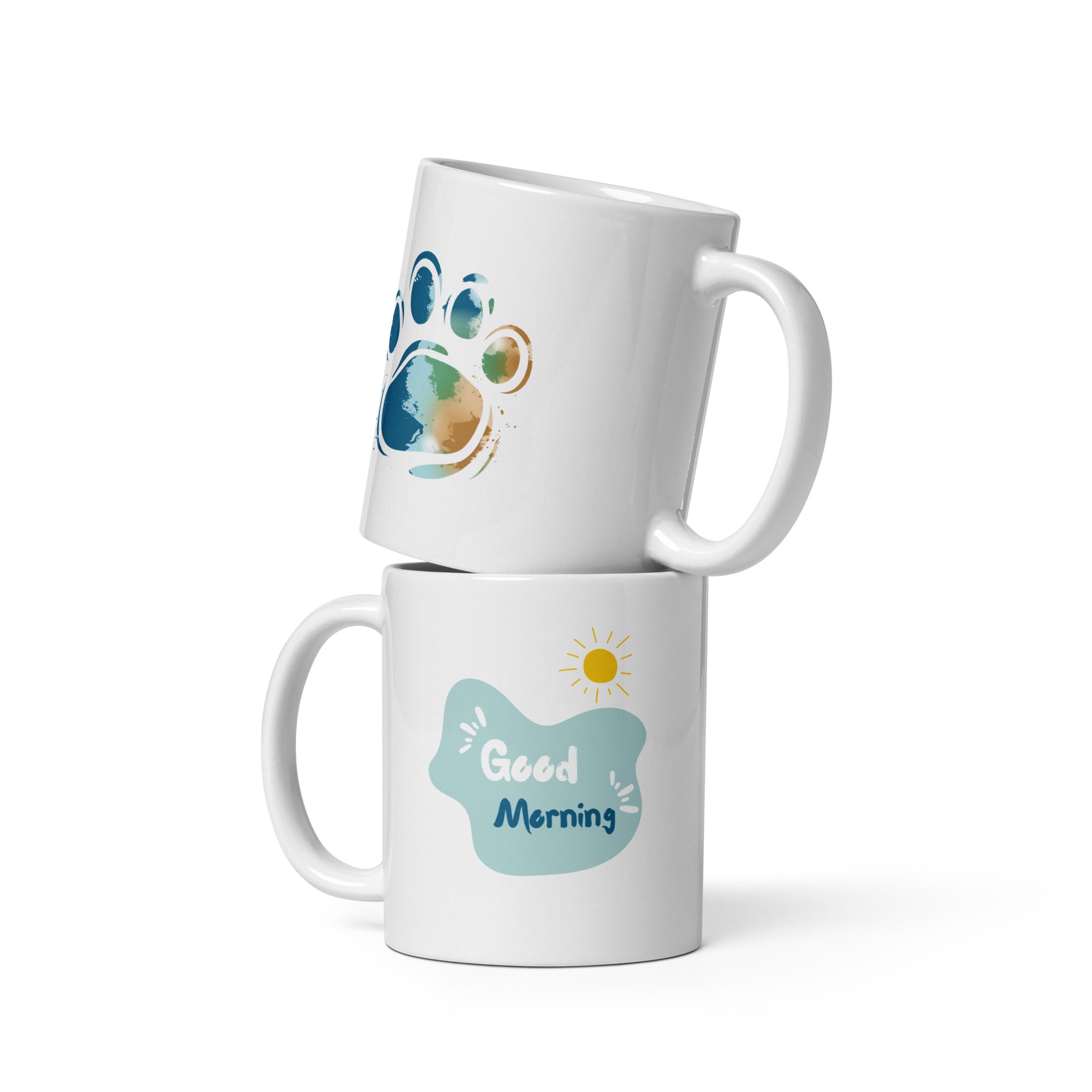 A set of two ceramic mugs, one with a 'Good Morning' message and a paw print design, and the other with a 'Paw Print Earth' design. Both mugs have a glossy white background with colorful prints.